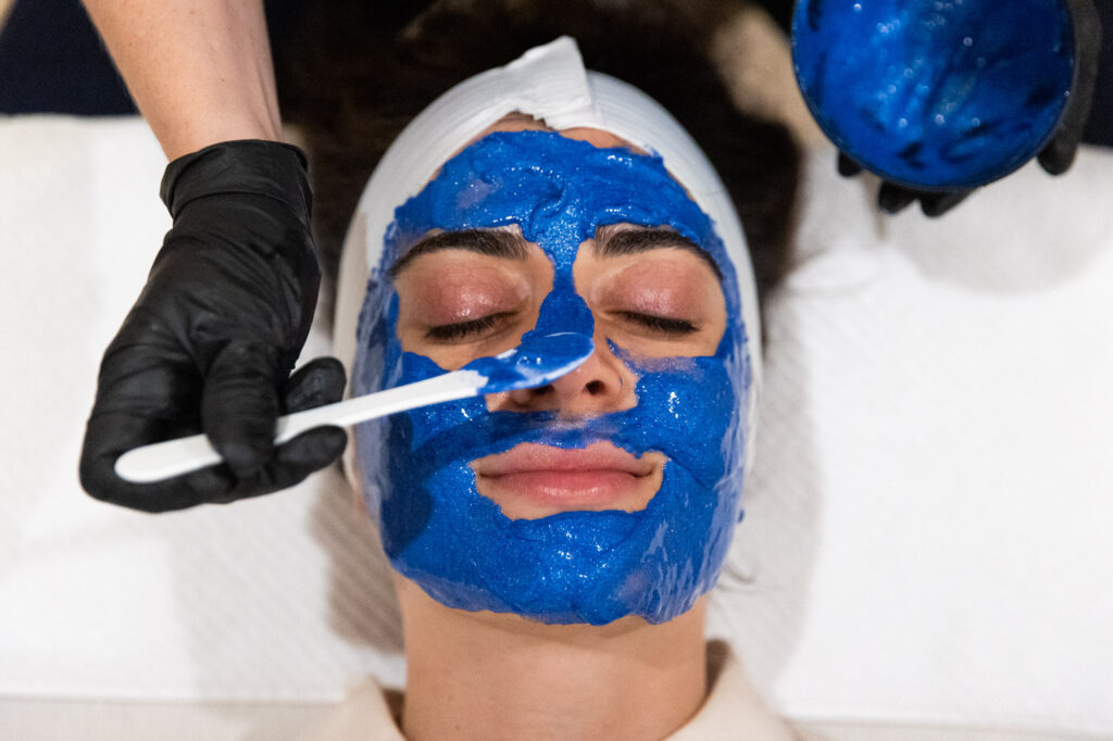 A patient lies down as a provider applies a chemical solution to their face before they undergo one of our most popular facials in Cleveland.