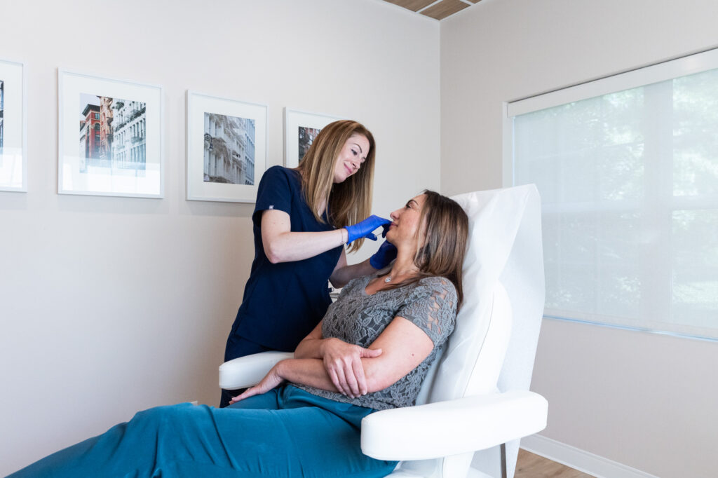 A patient relaxes in a treatment chair as one of our specialists carefully administers a facial dermal filler to combat her muscle loss from weight loss injections near Rocky River, OH.