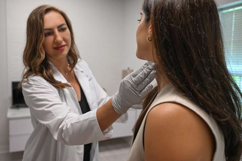 A female physician is putting her hand up to a woman's neck after she received treatment for skin tightening in Westlake, OH.