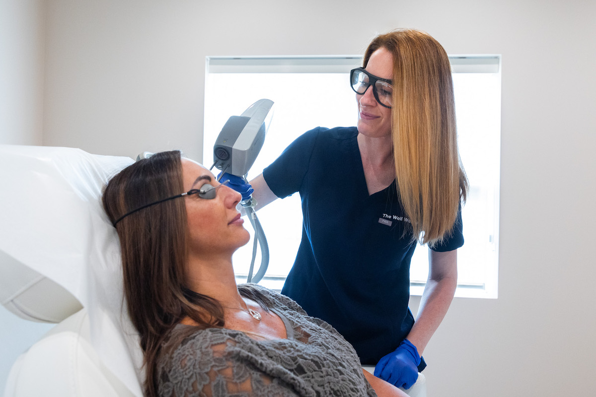 A Phases provider performs a patient's skin treatment using a facial laser near Cleveland.