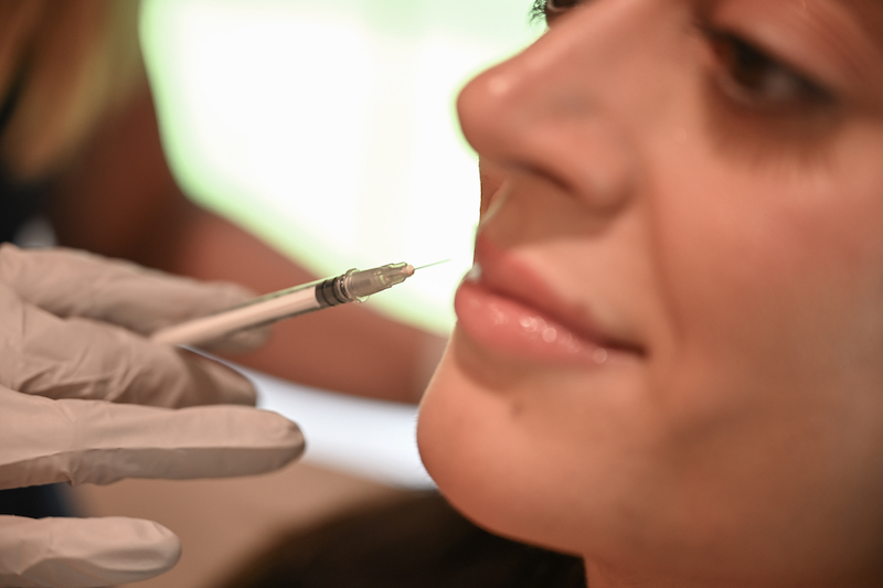 A Well Westlake injector is injecting chin filler in Westalke, OH, into a woman's chin.