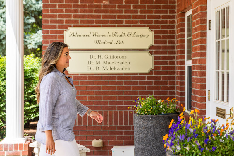 A woman is walking into The Well Westlake for her treatment for FaceTite near Cleveland.