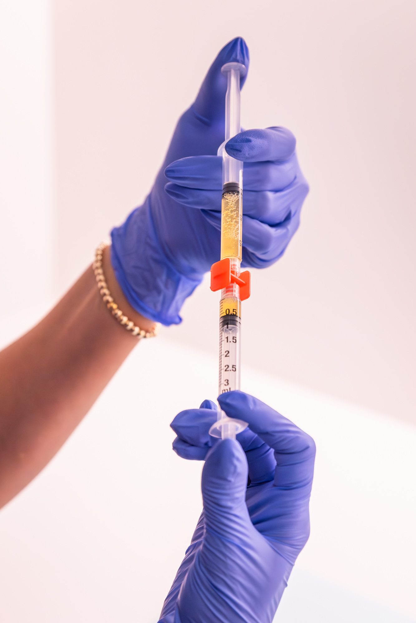 Close up of gloved hands prepping a syringe for PRP injections in Westlake.